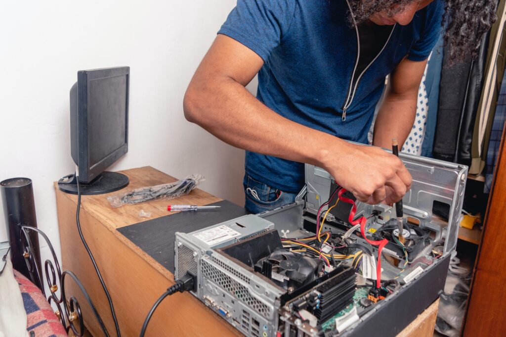 young brunette man at home cleaning and repairing computer case